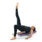 Woman lying on purple textured foam roller performing leg lift exercise on white background