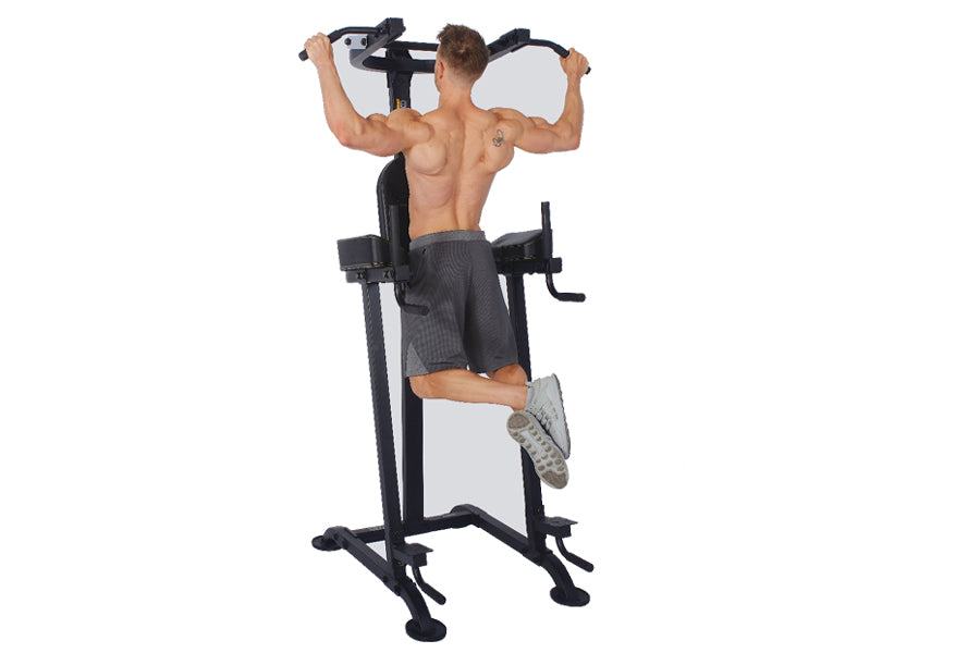 Man using black vertical knee raise power tower with pull-up bar on white background
