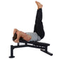 Man performing leg raise exercise on black Powertec Streamline Utility Bench with adjustable backrest and leg extension