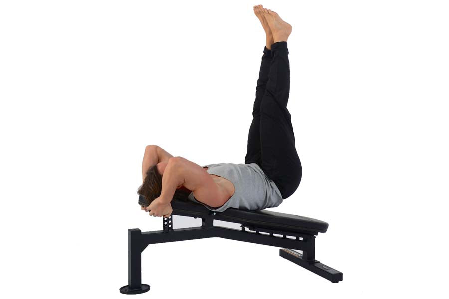 Man performing leg raise exercise on black Powertec Streamline Utility Bench with adjustable backrest and leg extension