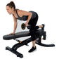 Woman performing dumbbell exercise on black adjustable weight bench with leg extension attachment