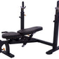 Black adjustable weight bench with leg extension attachment, upright bars with padded shoulder supports, and leg press platfo