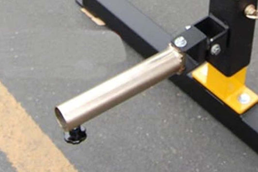 Warrior Power Rack Single Landmine Attachment with silver cylindrical tube and black and yellow base on gray floor