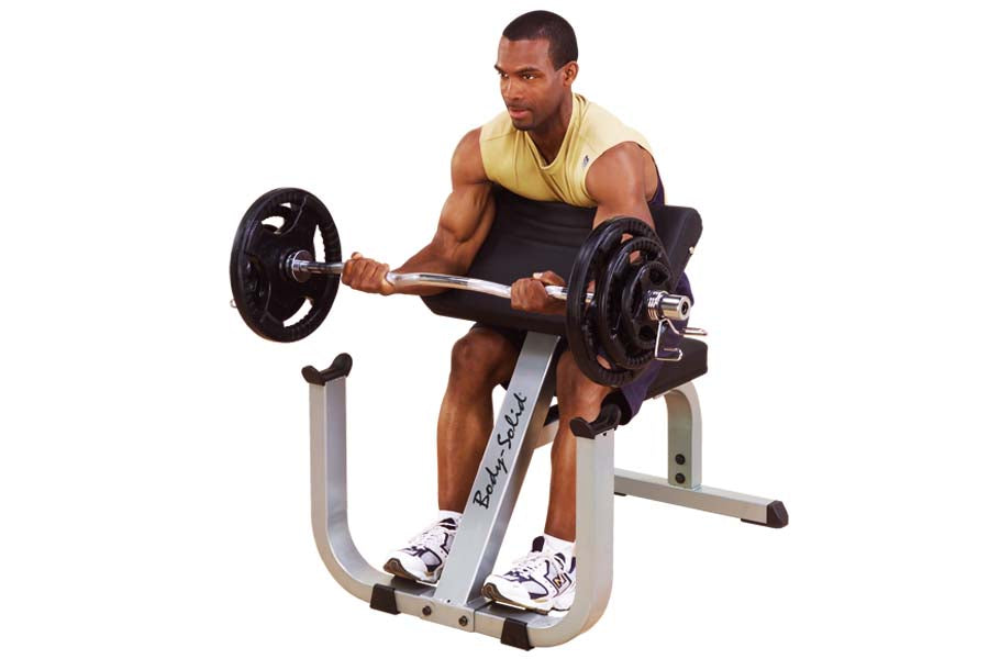 Man performing bicep curl on gray and black preacher curl bench with barbell weights, wearing yellow tank top and black short