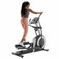 Woman exercising on ProForm Carbon E10 elliptical machine with gray and black frame, worn against white background