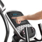 Hand operating digital console on ProForm Carbon EL elliptical with blue display and black controls, worn by user on white ba