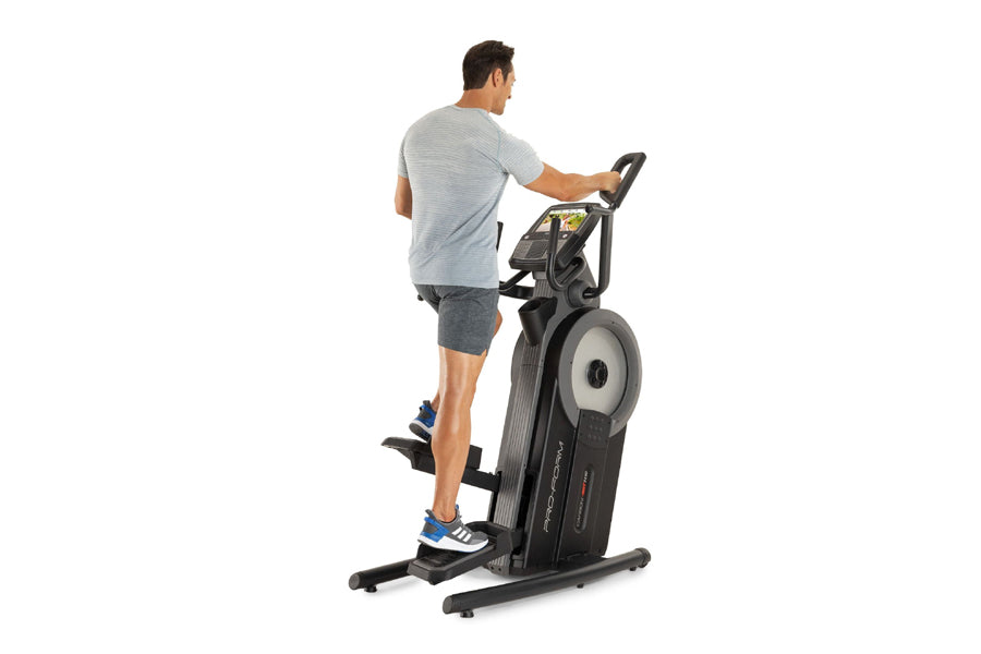 Man exercising on black ProForm elliptical with digital display, white flywheel, and handlebar grips against white background