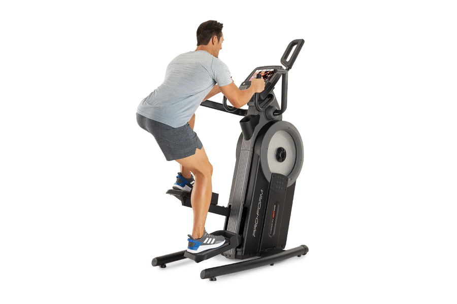 Man using black and gray ProForm elliptical machine with digital display, shown in side view against white background