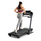 Woman in burgundy sports bra and gray leggings running on black ProForm treadmill with digital console, white background