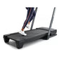 Black ProForm Carbon TL treadmill with gray uprights, person wearing navy leggings and white sneakers running on belt