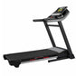 Black folding treadmill with digital display console, gray accents, and red foot pedals on white background