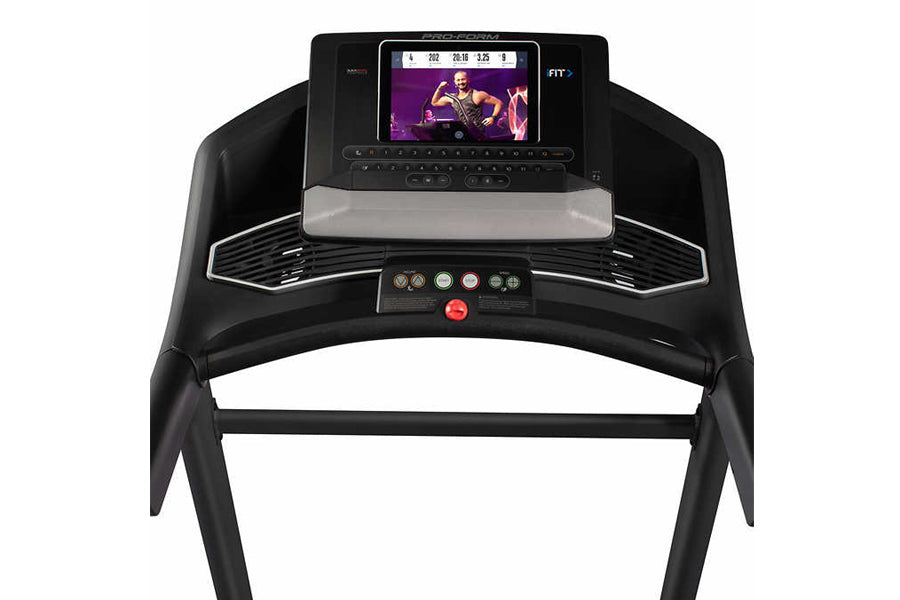 Black ProForm Trainer 12.0 treadmill with touchscreen display showing workout video, control panel with buttons, and dual han