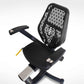 Black recumbent exercise bike with perforated backrest, adjustable armrests, and digital console, shown from side angle on wh