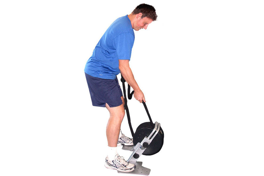 Man wearing blue t-shirt and navy shorts using Ropeflex RX2000 rope trainer with black wheel on white background