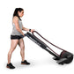 Woman using black Ropeflex RX2200 horizontal rope trainer with maroon accents on white background