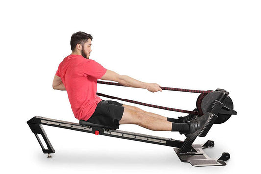 Man in red t-shirt and black shorts using black Ropeflex RX3200 rowing machine with rope handles on white background