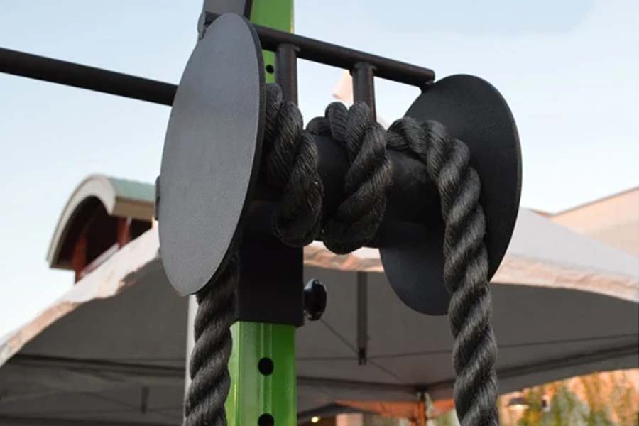 Black rope pull attachment with dual handles mounted on green metal frame with black pulleys
