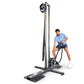 Man in blue shirt and navy shorts using tall vertical rope training machine with pulley system on white background