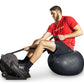 Man in red shirt and black shorts using black Ropeflex rope trainer while seated on exercise ball