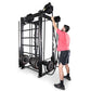 Man in pink shirt using black steel cable machine with weight plates, shown on white background
