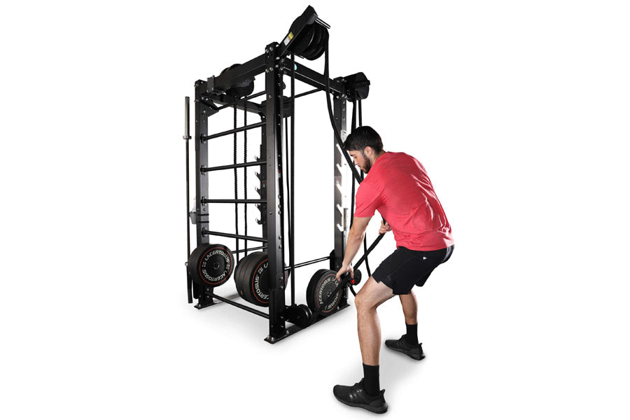 Man in red shirt using black steel cable machine trainer with dual weight stacks on white background