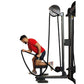 Man in red shirt using black rope trainer exercise machine on white background