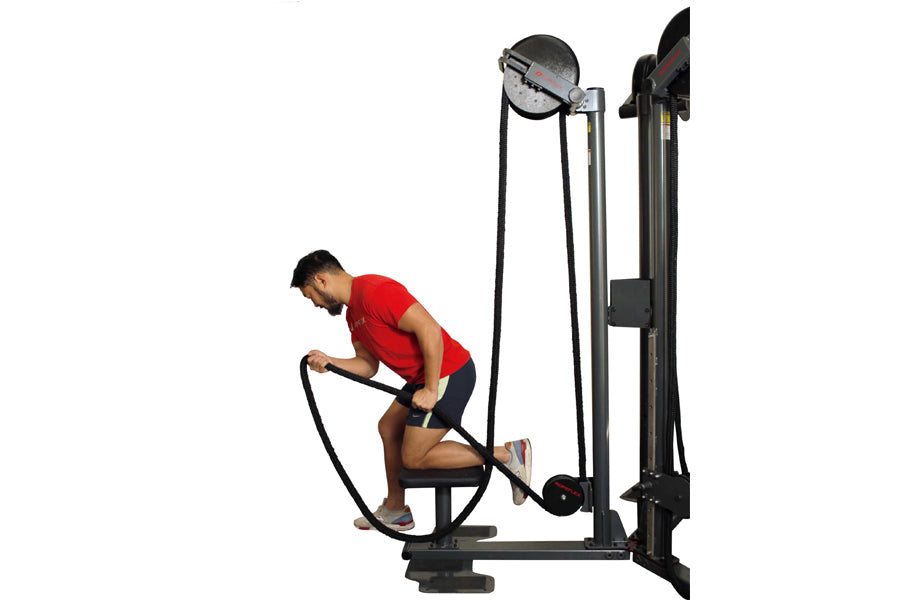 Man in red shirt using black rope trainer exercise machine on white background