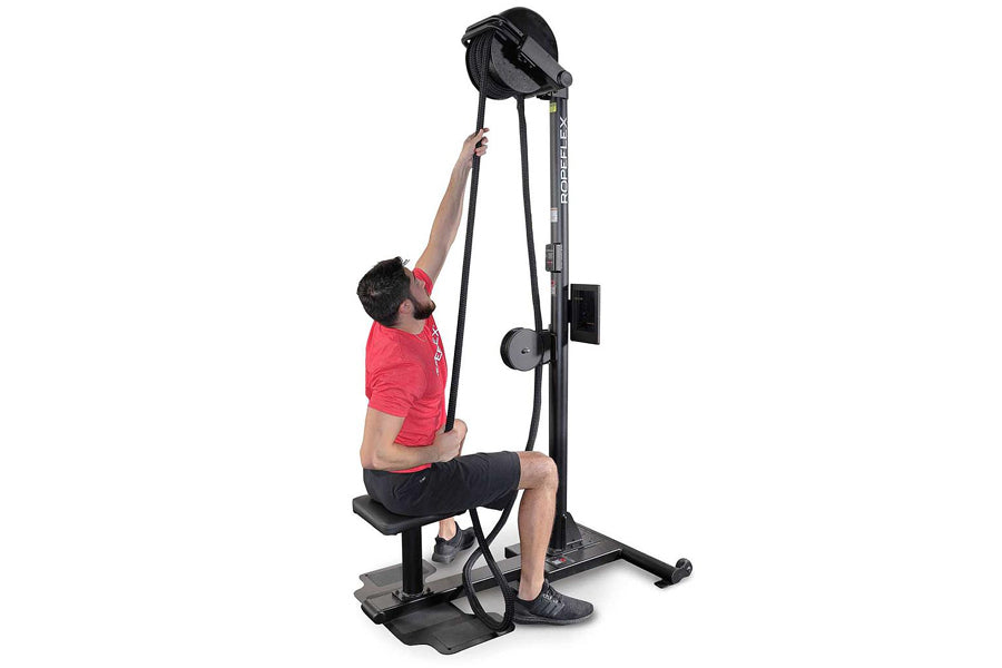 Man in red shirt using black upright rope trainer machine with pulley system on white background