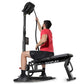 Man in red shirt using black Ropeflex RX2500 upright rope trainer with overhead pulley system on white background