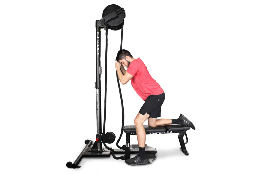 Man in pink shirt using black Ropeflex rope trainer machine with pulley system on white background