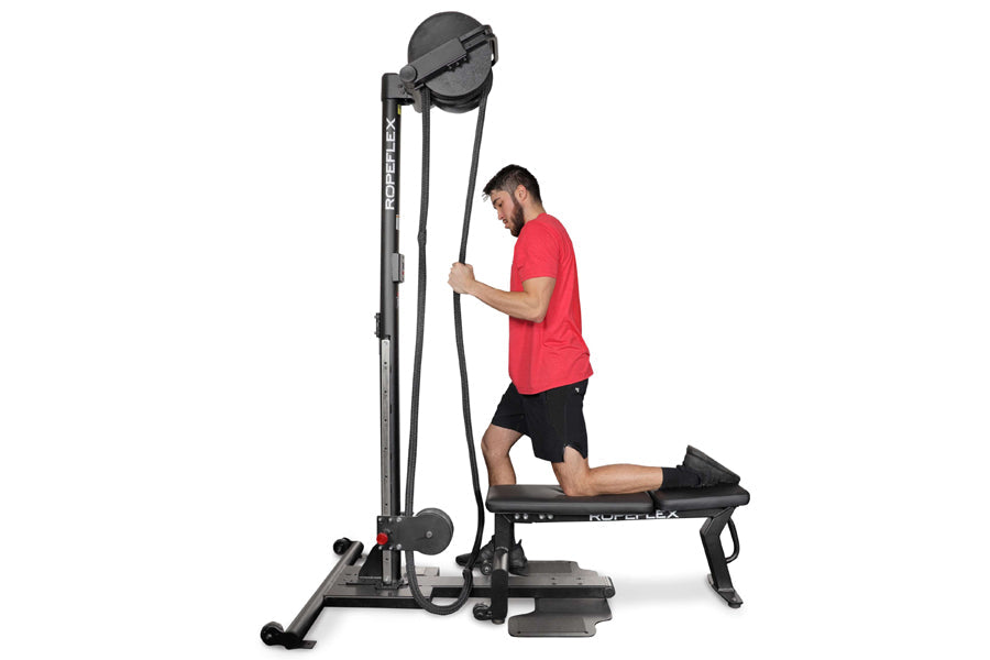 Man in red shirt using black Ropeflex RX2500 upright rope trainer with pulley system on white background