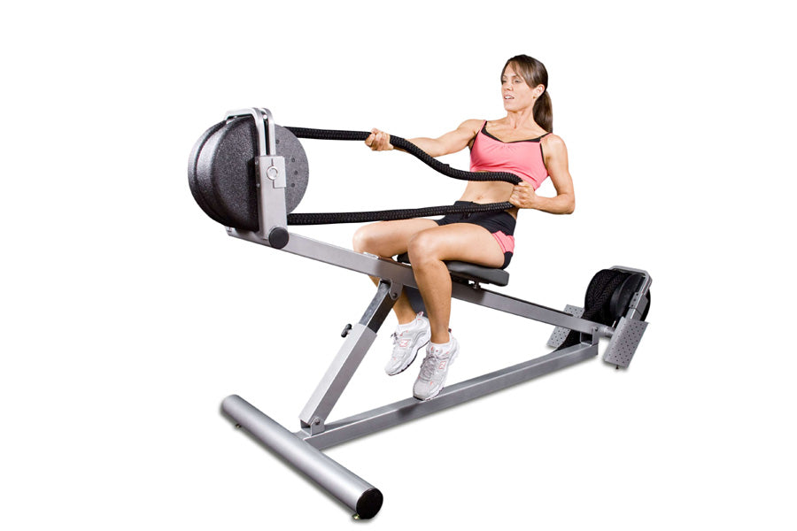Woman in pink sports bra and black shorts using gray Ropeflex RX3300 incline rope trainer with black rope and round weight ba