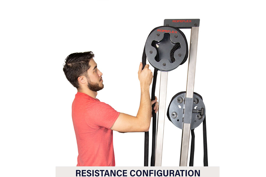 Man in red shirt using Ropeflex RX505 rope drum attachment with dual gray resistance wheels on white background