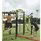 Two men using yellow and black modular fitness rig with pull-up bar and rope attachment on outdoor grass field