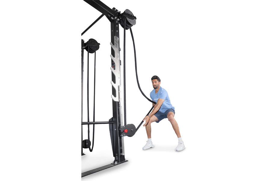 Man in blue shirt using black Ropeflex rope trainer machine with dual pulleys on white background