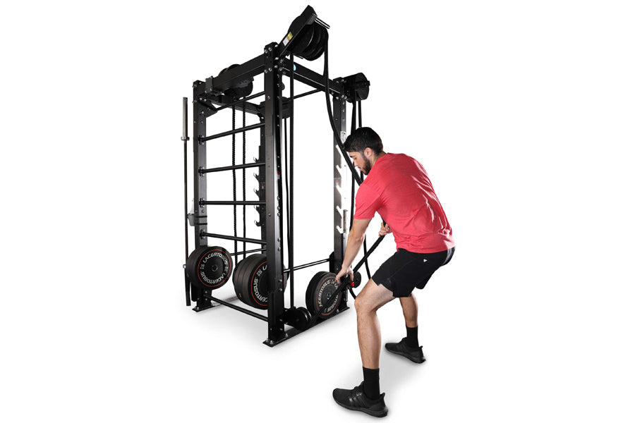 Man in red shirt using black metal cable machine with rope attachments on white background