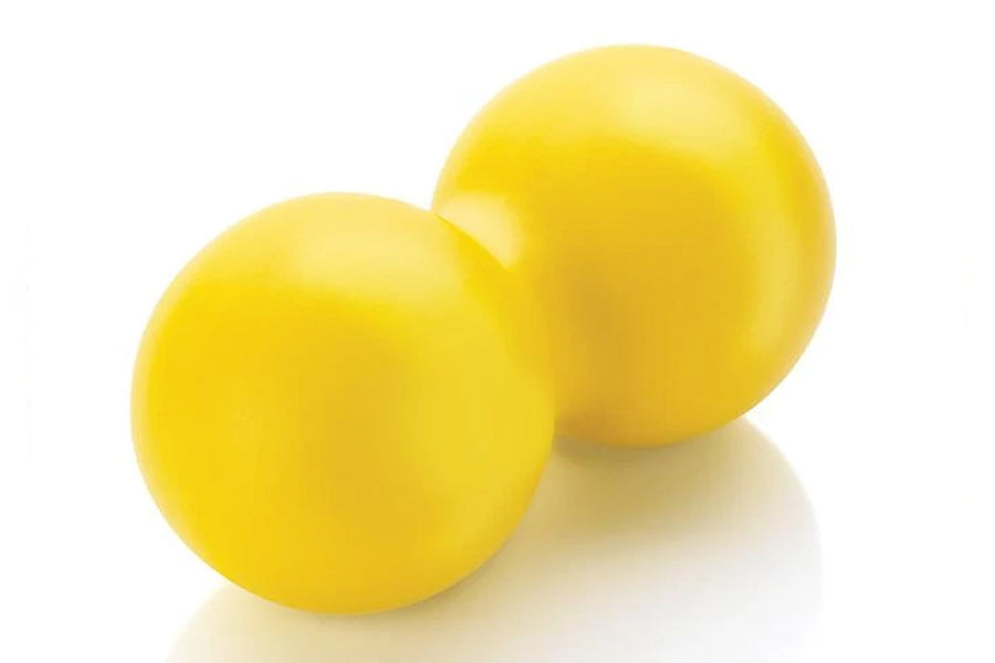 Two bright yellow massage balls with glossy finish on white background