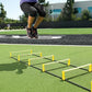 Athlete jumping over yellow and black agility ladder on artificial turf field during training