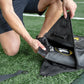 Black nylon sports training bag with yellow logo, worn by model on athletic field