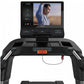Black TRUE Stryker Slat Treadmill with interactive touchscreen displaying fitness content, viewed from front on white backgro