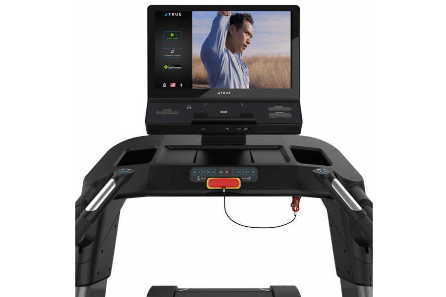 Black TRUE Stryker Slat Treadmill with interactive touchscreen displaying fitness content, viewed from front on white backgro