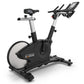 TRUE Surge indoor exercise bike with black and silver frame, white flywheel, adjustable seat and handlebars, digital display 