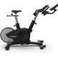 TRUE Surge indoor cycle with black frame, gray accents, upright seat, and dual handlebars on white background