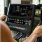 Schwinn 190 upright exercise bike console with digital display showing metrics, held by user's hands during indoor workout