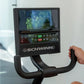 Schwinn 290 recumbent exercise bike with digital display console showing fitness metrics, black frame and handlebars, hand on
