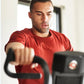 Man wearing red t-shirt using black Schwinn Airdyne AD7 exercise bike indoors