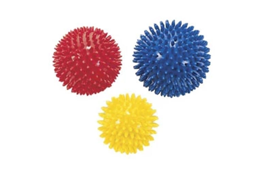 Three textured massage balls in red, blue, and yellow with spiky rubber nubs on white background