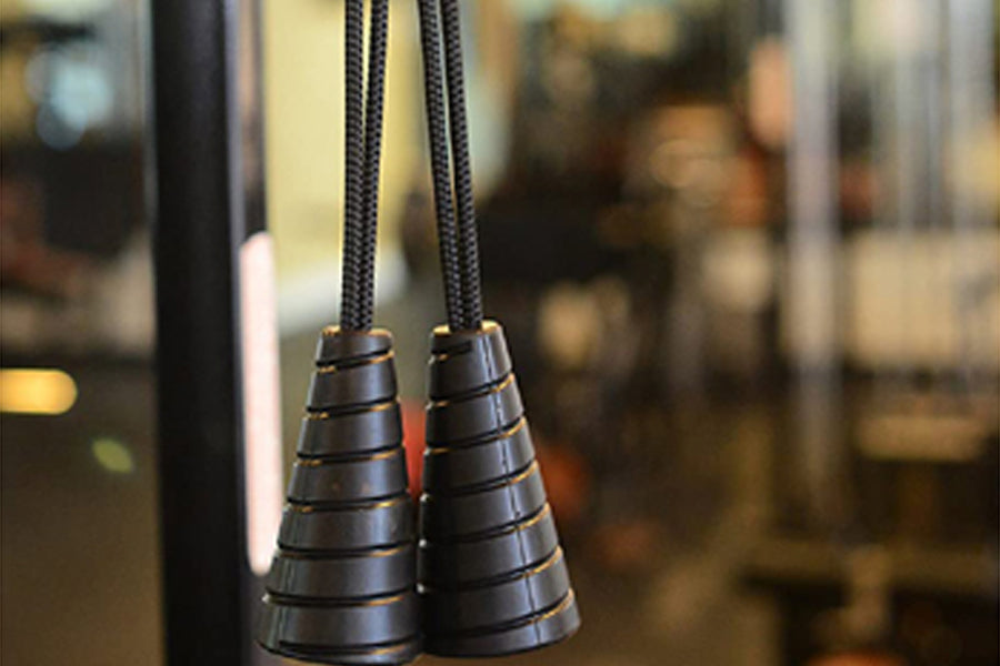 Black spiral jump rope handles with gold accents and braided cords, close-up view