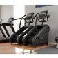 Black and gray StairMaster Gauntlet 4G StepMill with digital display in gym setting next to treadmill and dumbbell rack