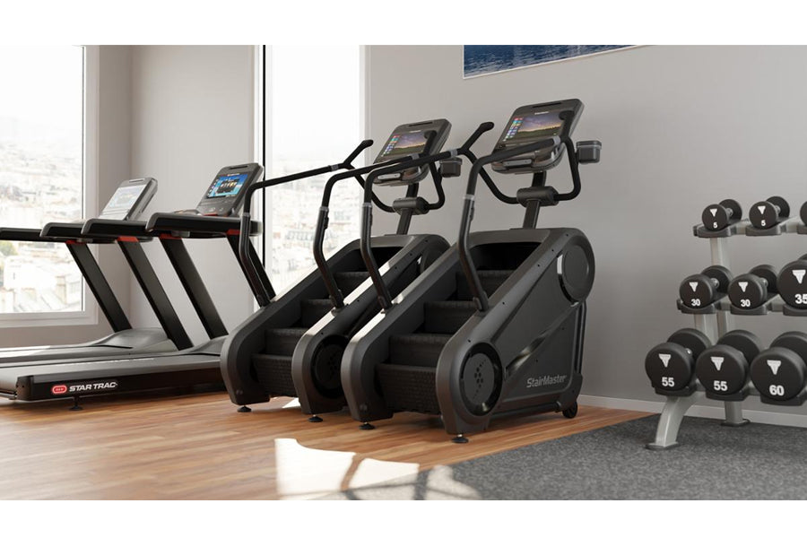 Black and gray StairMaster Gauntlet 4G StepMill with digital display in gym setting next to treadmill and dumbbell rack